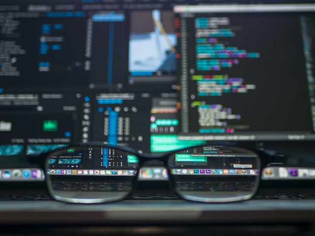glasses next to a computer full of coding language